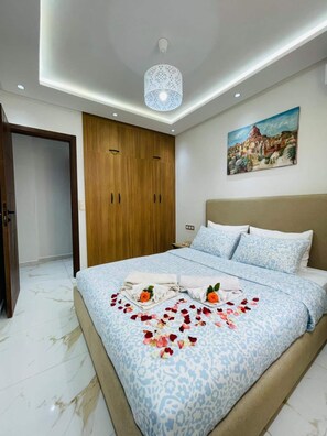 Tabla de planchar con plancha, cuna de viaje y ropa de cama 