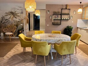 Un comedor con una mesa redonda, sillas amarillas y un papel tapiz estampado.