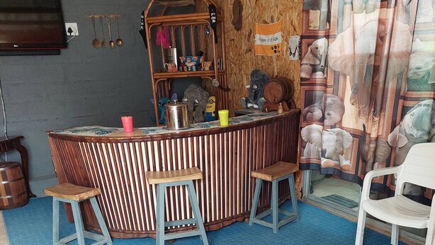 Un espace bar avec des tabourets, un comptoir et un décor mural.