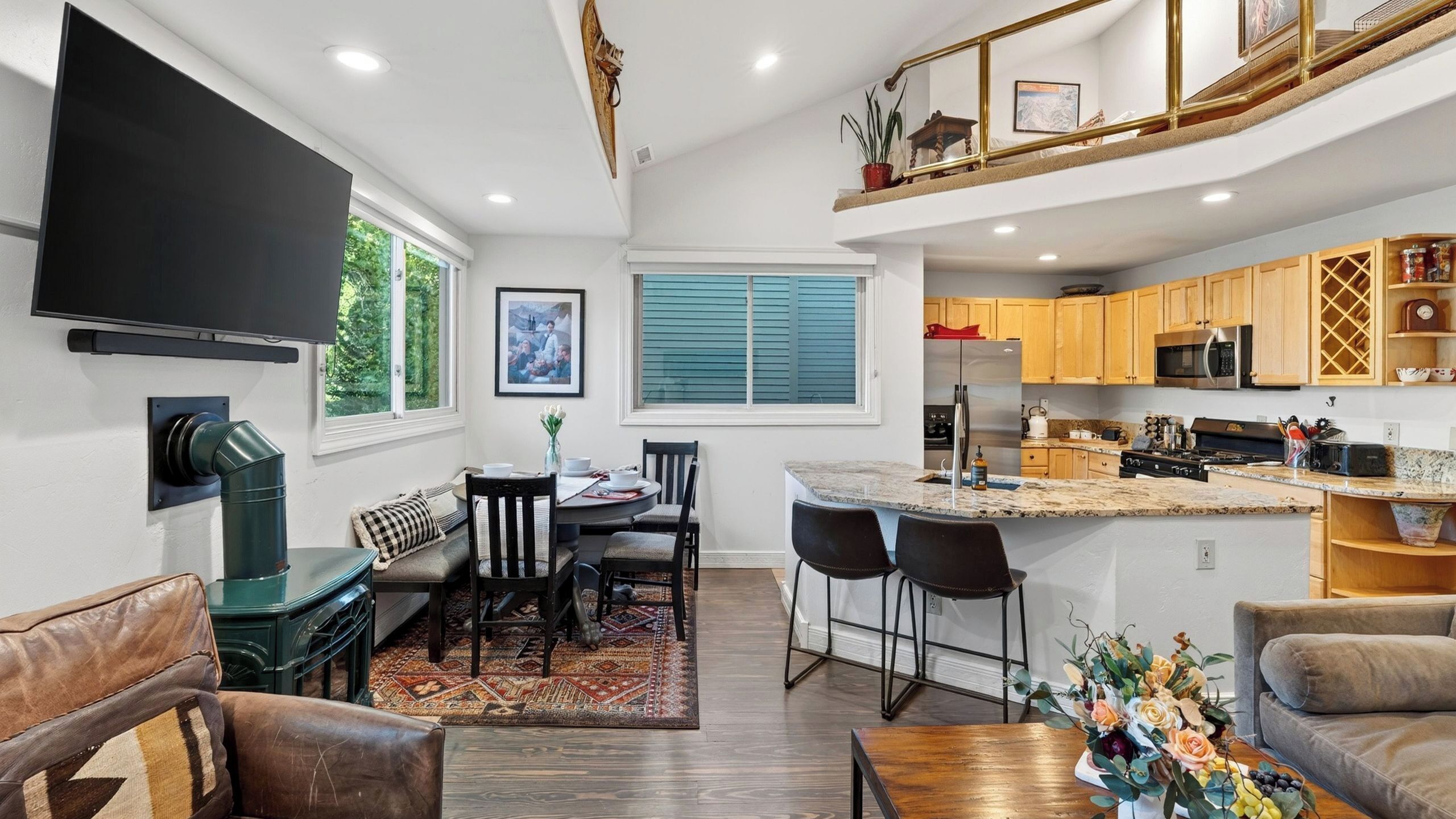 A modern kitchen with wooden cabinets, a built-in oven, and a stainless steel refrigerator.