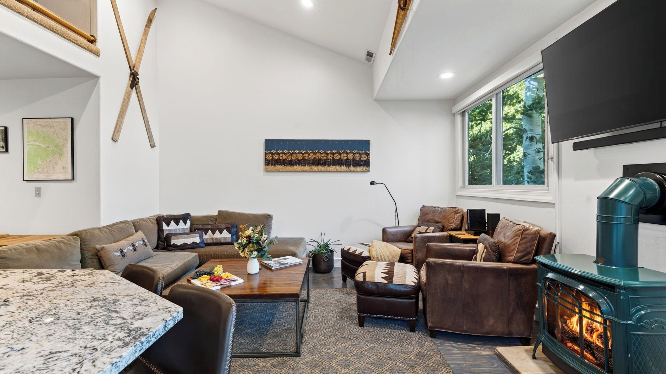 A modern living room with a fireplace, sofas, a coffee table, and artwork on the walls.
