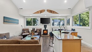 A modern living room with a fireplace, a dining area, and large windows. - Telluride Lodge 518 by Avantstay Communal Hot Tub + Sauna + Mountain Views Steps to Gondola (Telluride)