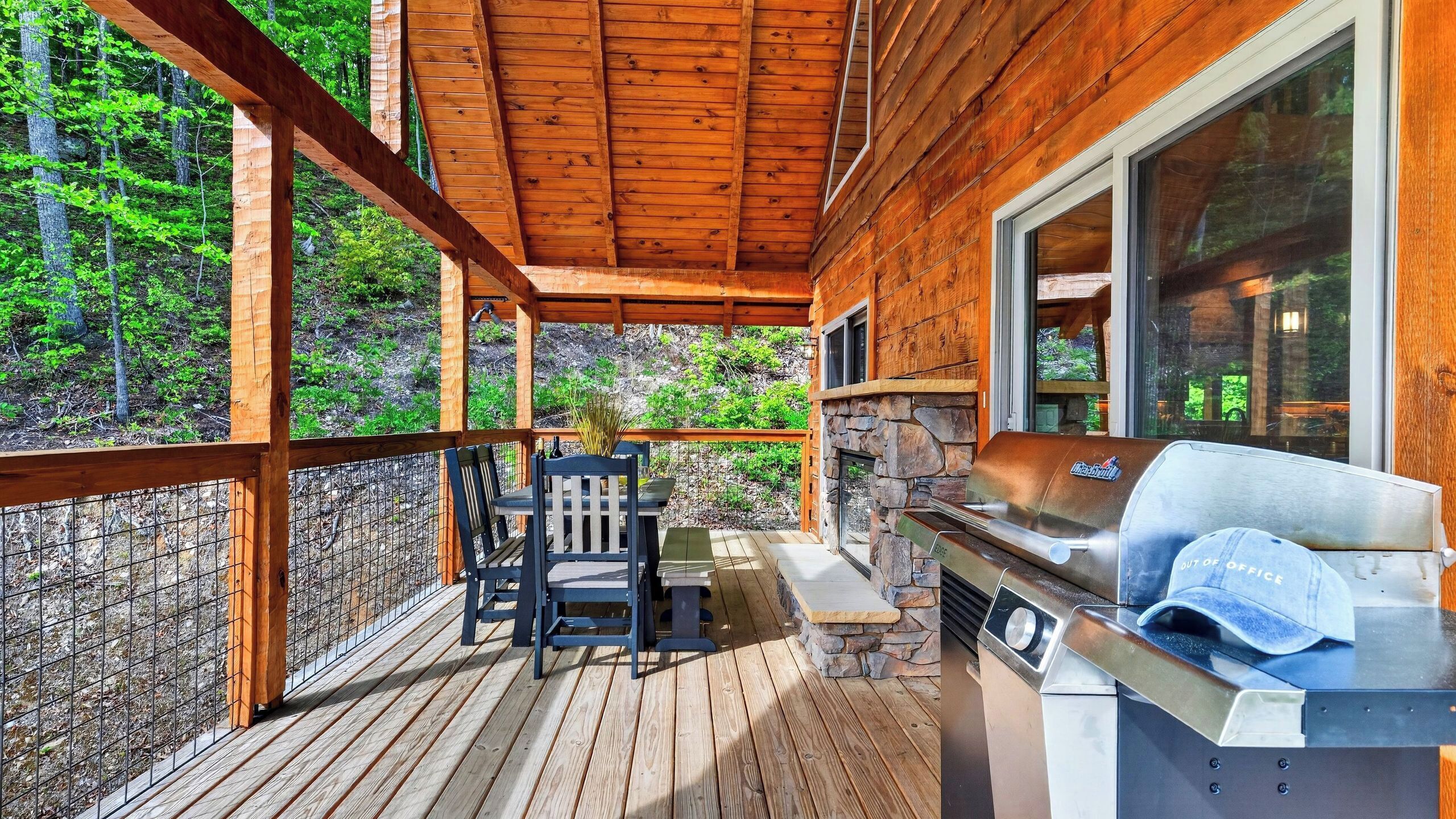 A wooden deck with a grill and seating area.