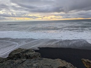 A beach with waves and a cloudy sky. - Blue whale cove | Cliffside Ocean Views | Hot tub (Whitethorn)