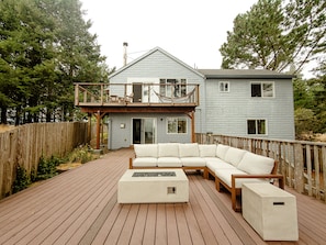 A house with a deck, a sectional sofa, and a fire pit. - Blue Whale Cove | Cliffside Ocean Views (Whitethorn)