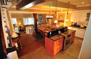 A spacious kitchen with a central island, wooden cabinets, and a built-in oven.