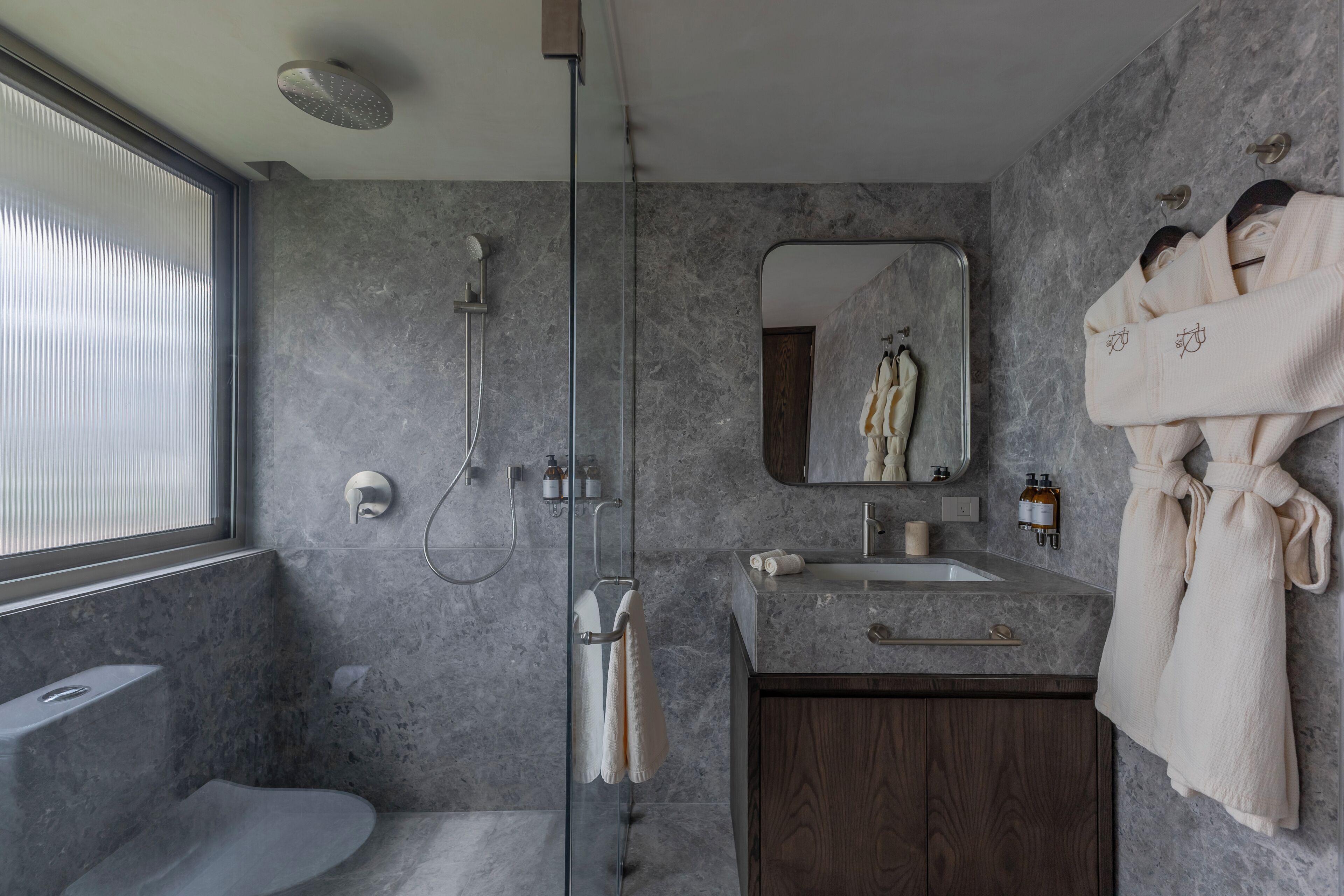 Une salle de bain moderne avec une douche à parois de verre, un meuble-lavabo et un miroir.