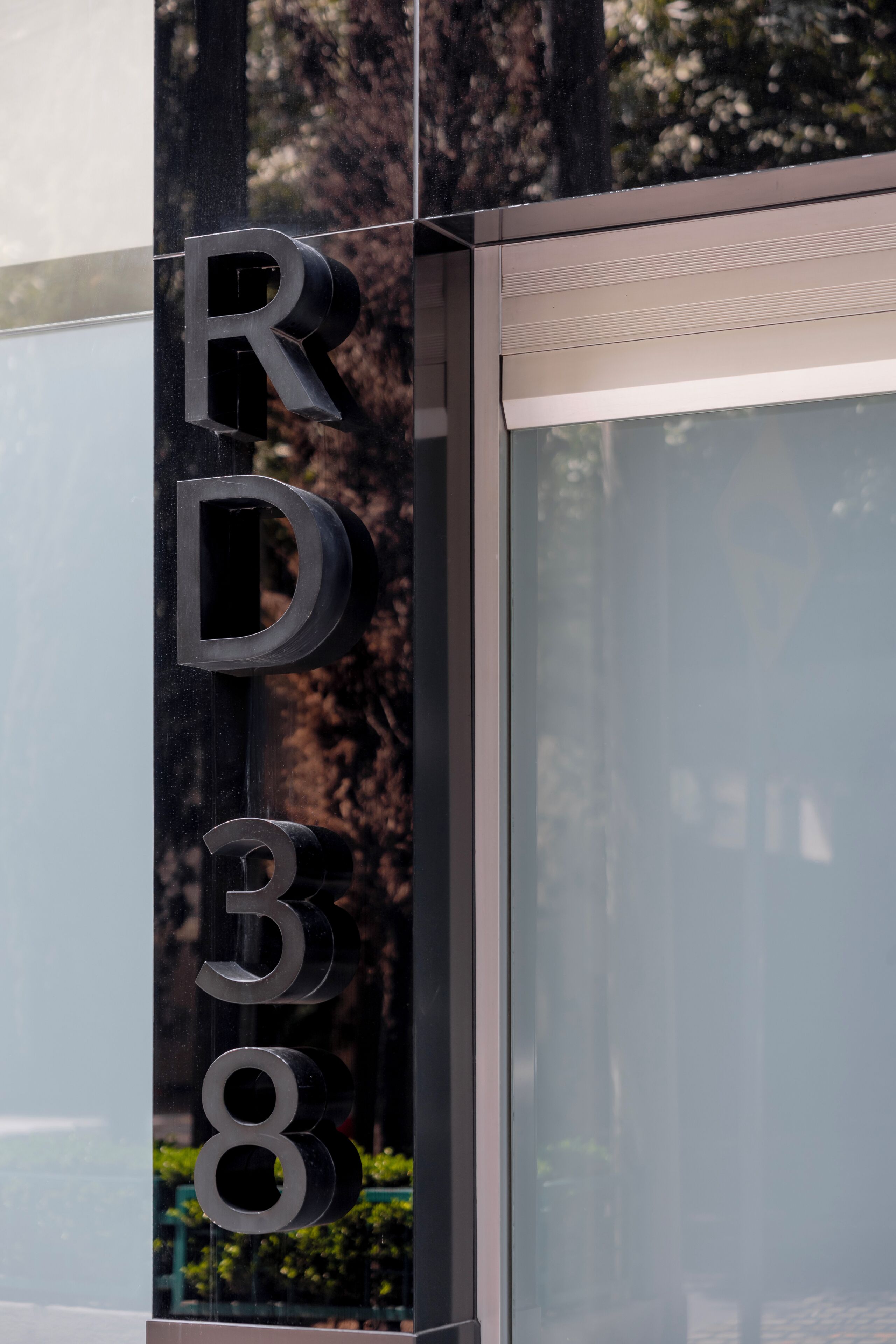 Una puerta de cristal con las letras 'RD 38' sobre una estructura metálica.