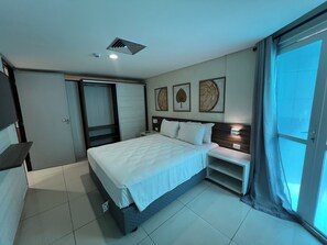 Ein Hotelzimmer mit Bett, Nachttischen, einem Kleiderschrank und einem großen Fenster.