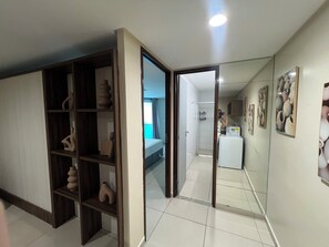 Ein Hotelzimmer mit großem Kleiderschrank, einem Bett, einem Badezimmer und einer Küchenzeile.
