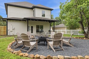 A house with a covered patio, outdoor seating, and a fire pit. - Gathering Home - Sleeps 10 - 4 King Beds 4.5 Baths (College Station)