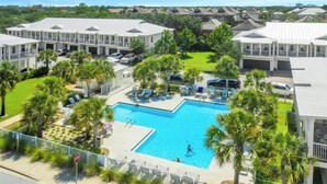 A resort with a central swimming pool, multiple guest rooms, and a well-maintained lawn. - Crystal Dream at 111 | Golf Cart & Bikes | Pool | Walk to Beach & Destin Commons (Destin)