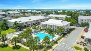 A resort with multiple buildings, a swimming pool, and a view of the ocean. - Crystal Dream at 111 | Golf Cart & Bikes | Pool | Walk to Beach & Destin Commons (Destin)