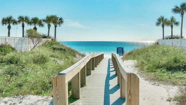 A wooden boardwalk leading to a beach with palm trees and a clear sky. - Crystal Dream at 111 | Golf Cart & Bikes | Pool | Walk to Beach & Destin Commons (Destin)
