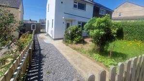 Een woonstraat met huizen, een grindpad en groen.