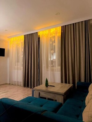 Appartamento familiare, 1 letto king con divano letto, balcone, vista città | Area soggiorno