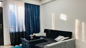 A modern living room with a sofa, a coffee table, and a blue rug.