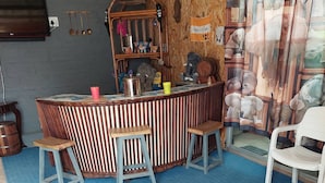 A bar area with stools, a counter, and a decorative backdrop.
