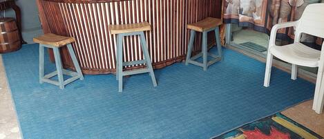 A bar area with stools, a counter, and a decorative backdrop.