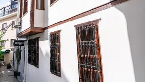 A white building with wooden window frames and a balcony. - bütünoğlu pansiyon (Antalya)