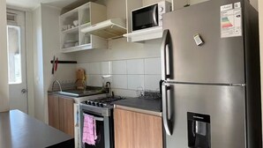 A modern kitchen with a stainless steel refrigerator, a microwave, and a built-in oven.