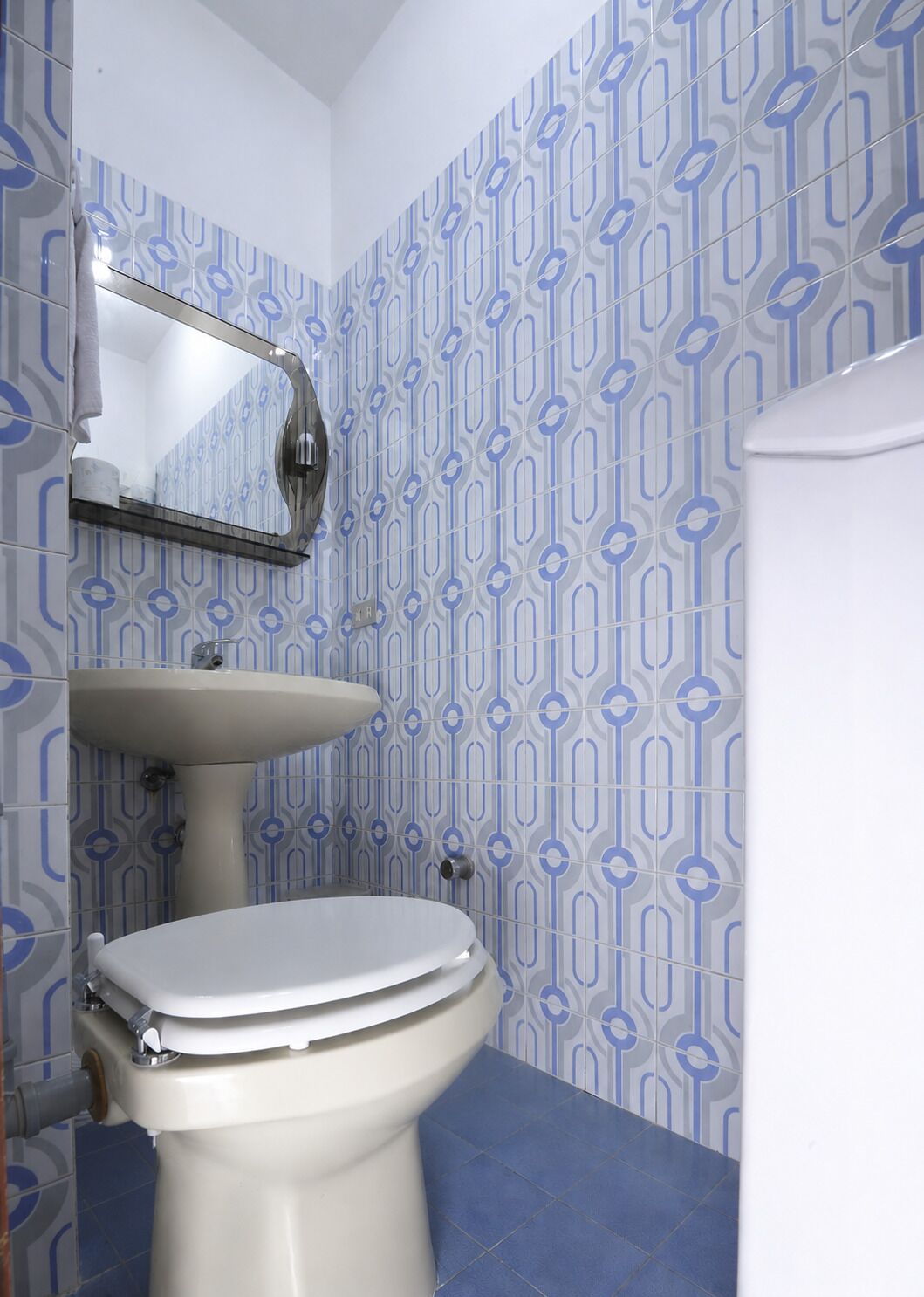 Une salle de bain avec des toilettes, un lavabo et un miroir.