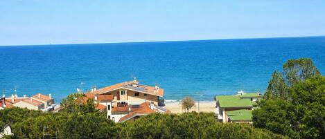A coastal view with buildings, a beach, and the sea.