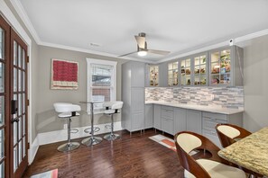 A kitchen with grey cabinets, a white countertop, and a ceiling fan. - ATL Oasis with Private Yard and Easy City Access (Atlanta)