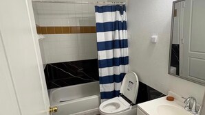 Un baño con bañera, inodoro y lavabo.