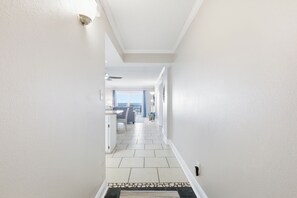 A hallway with a dining area, a ceiling fan, and a view of the ocean. - Sunrises, blue water, white sand and sunsets! Gulf front condo (Panama City Beach)