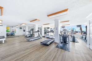 A gym with treadmills, elliptical machines, and exercise balls. - Sunrises, blue water, white sand and sunsets! Gulf front condo (Panama City Beach)