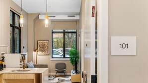 Un bagno moderno con lavandino, specchio e portasciugamani. Si vede una finestra con vista su auto parcheggiate e alberi.