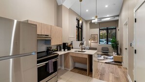 Una cucina moderna con forno a incasso, macchina da caffè e zona pranzo con scrivania e sedia.