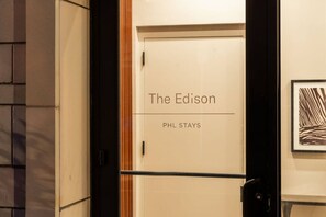 Puerta de una habitación de hotel con la etiqueta 'The Edison' y una placa que indica 'PHL STAYS'.