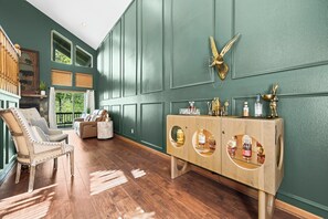 A room with a wooden cabinet with glass doors, a plush armchair, and a large window. - Spacious 3-Bedroom Resort Stay Near Golf & Pool (Whittier)