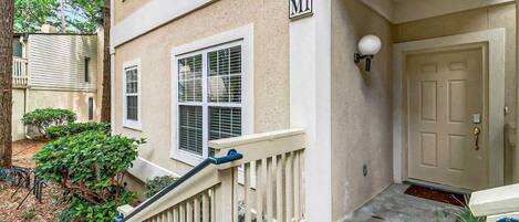 A residential building with a white exterior, a front door, and a mailbox.