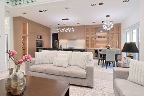 A modern living room with a sofa, a coffee table, and a vase with flowers.