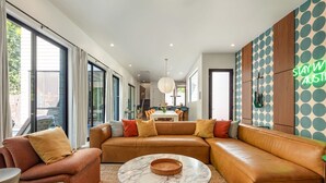 Een moderne woonkamer met een leren modulaire bank, een marmeren salontafel en een behang met patroon.