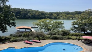 A swimming pool with a curved edge, surrounded by lounge chairs and a deck area. - Tremendous 4-bedroom house with Boat Dock, Pool and Hot Tub in charming Harriman (Harriman)