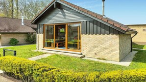 A small, single-story house with a sloped roof, a large sliding glass door, and a brick exterior. - 2 bedroom nice home in Westende (Westende)