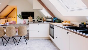 A modern kitchen with a skylight, a dining area with chairs, and a visible laundry area. - Gorgeous home in Knesselare with sauna (Knesselare)