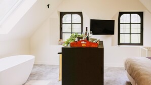 A room with a black desk, two windows, a white bathtub, and a bed. - Gorgeous home in Knesselare with sauna (Knesselare)