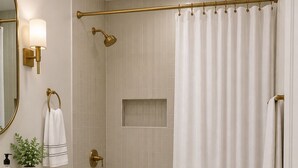 Een badkamer met een bad, toilet, wastafel en douche.