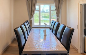 Una mesa de comedor con seis sillas, una vela y vistas por una ventana.