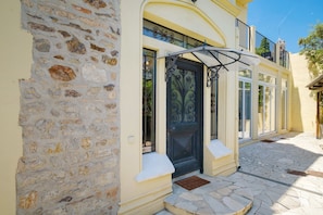 A building with a stone facade, a black ornate door, and a balcony with black railings. - “Grand 2-Bedroom” Apartment with Shared Terrace, Wi-Fi, and Air Conditioning (Cannes)