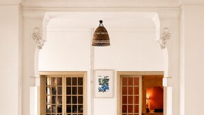 A hallway with patterned floor tiles, a black chair, a small wooden table, and a framed sign on the wall. - Room in private villa, charm, comfort, near Velodrome & beaches-Private parking lot (Marseille)