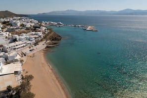 Eine Küstenstadt mit weißen Häusern, einem Sandstrand und blauem Meer.