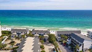 A coastal hotel with multiple buildings, a parking area, and a beach view. - The Coastal View Gulf Front Condo in Seagrove Beach Sleeps 7 with a Pool (Santa Rosa Beach)