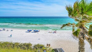 A beach with clear turquoise water, white sand, and palm trees. - The Coastal View Gulf Front Condo in Seagrove Beach Sleeps 7 with a Pool (Santa Rosa Beach)