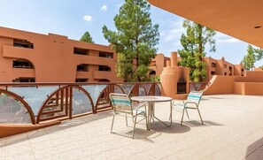 A terrace with a pool, outdoor seating, and a view of a building with multiple balconies. - CASA GINA - Anasazi Village - Pool View (Phoenix)